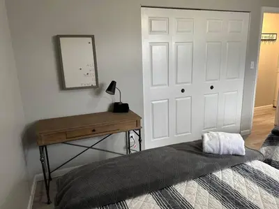 a bedroom with a bed and a desk and a door at Modern Retreat - Newly Remodeled Gem in Englewood