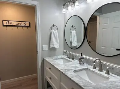 a bathroom with two sinks and a large mirror at Modern Retreat - Newly Remodeled Gem in Englewood