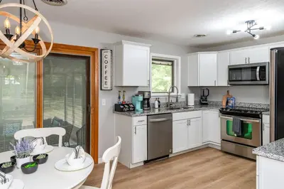 a kitchen with white cabinets and a table and chairs at Sweet Magnolia - Newly Remodeled Ranch in Englewood