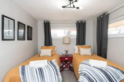 two beds in a small bedroom with black curtains at Sunny Ranch - Newly Remodeled in Dayton