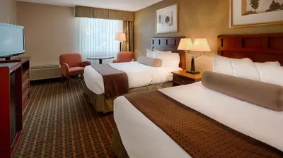 a hotel room with two beds and a flat screen tv at Baymont Inn & Suites in Marietta