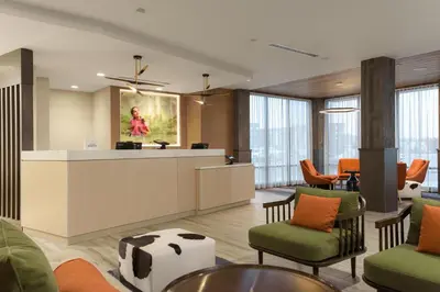 a lobby with a waiting area with cows on the wall at TownePlace Suites by Marriott Cincinnati Oakley in Cincinnati