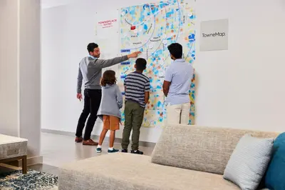 a group of people looking at a map on a wall at TownePlace Suites by Marriott Cincinnati Oakley in Cincinnati