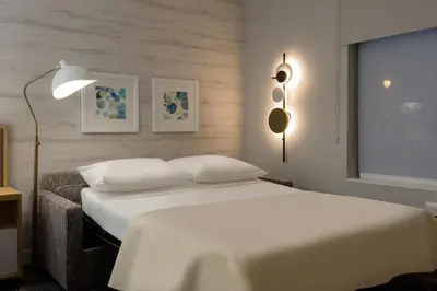 a bedroom with a white bed and a lamp at TownePlace Suites by Marriott Cincinnati Oakley in Cincinnati