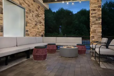 a patio with a couch and chairs and a table at Home2 Suites By Hilton Columbus Easton in Columbus