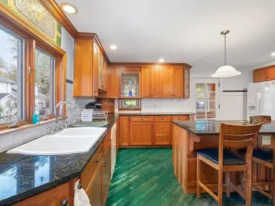 a kitchen with wooden cabinets and a large white sink at Willow Woods Retreat - Farmhouse - Patio & Nature in Kirtland