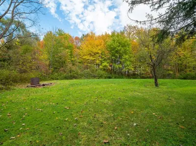 a park with a bench in the middle of a field at Willow Woods Retreat - Farmhouse - Patio & Nature in Kirtland