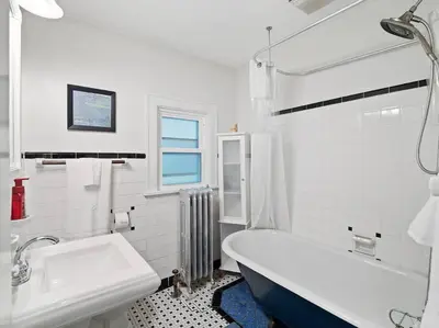 a white bathroom with a tub and a sink at Willow Woods Retreat - Farmhouse - Patio & Nature in Kirtland
