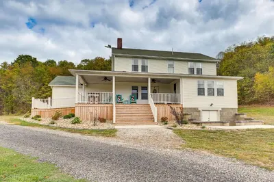 a white house with a porch and a driveway at Wooded Escape with Pond and Grill in Pleasant City! in Senecaville