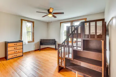 a living room with a staircase and a ceiling fan at Wooded Escape with Pond and Grill in Pleasant City! in Senecaville