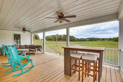 a porch with chairs and a table and a ceiling fan at Wooded Escape with Pond and Grill in Pleasant City! in Senecaville