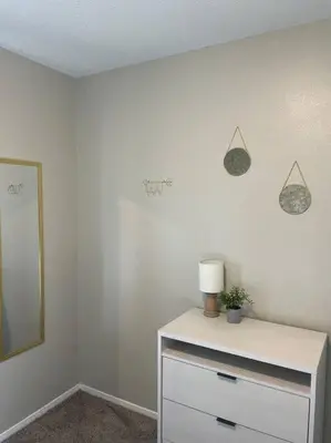 a white room with a dresser with a lamp and a mirror at Spacious 3-bedroom home in Archbold in Archbold