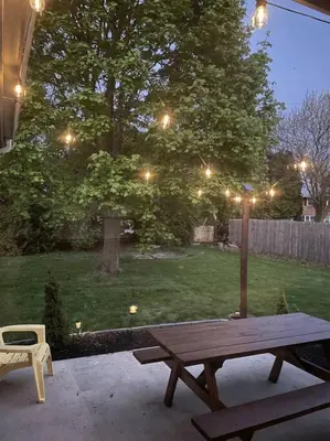 a wooden picnic table in a yard with a tree at Spacious 3-bedroom home in Archbold in Archbold