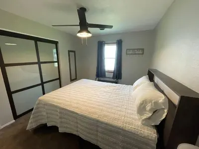 a bedroom with a bed with a ceiling fan at Spacious 3-bedroom home in Archbold in Archbold