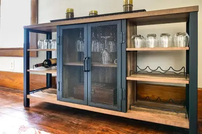 a cabinet filled with glasses and bottles of wine at Countryside Home in Wooster with Patio and Fire Pit in Wooster