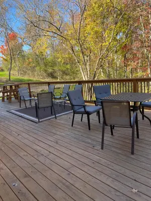 a deck with chairs and a table and benches at The Saige - Hot Tub, Fire Pit, and huge entertainment area in Logan