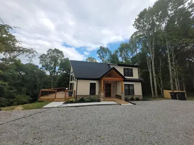 a house with a gravel driveway in front of it at The Quana - Hot tub, fire pit, and Huge Entertainment Area in Logan