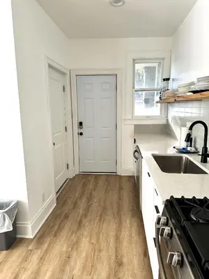 a kitchen with white counters and a sink and a door at Downtown Retreat - Cozy First Floor in Columbus