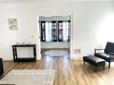 an empty living room with a table and a chair at Downtown Retreat - Cozy First Floor in Columbus
