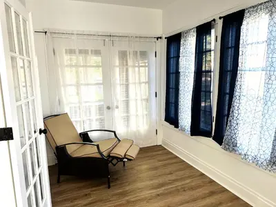 a chair sitting in a room with windows at Downtown Retreat - Cozy First Floor in Columbus