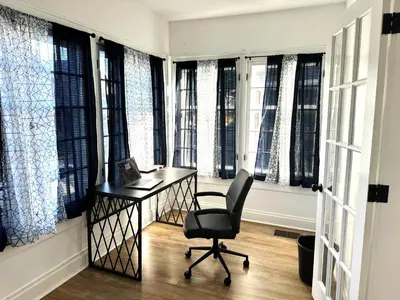 a office with a desk and a chair in front of windows at Downtown Retreat - Cozy First Floor in Columbus