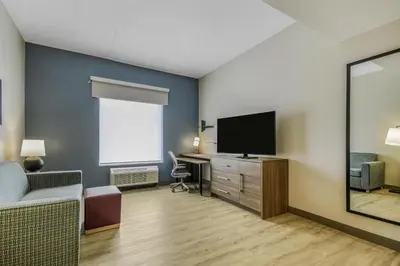 a living room with a tv and a desk at Home2 Suites By Hilton Cincinnati Midtown Oakley in Cincinnati