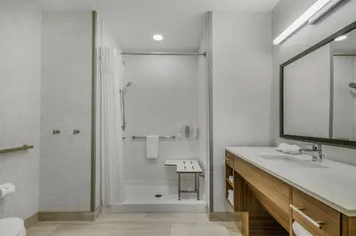 a white bathroom with a shower and a sink at Home2 Suites By Hilton Cincinnati Midtown Oakley in Cincinnati