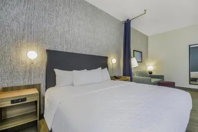 a hotel room with a bed and a chair at Home2 Suites By Hilton Cincinnati Midtown Oakley in Cincinnati