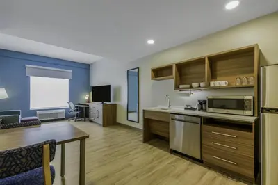 a kitchen and living room with a table and a couch at Home2 Suites By Hilton Cincinnati Midtown Oakley in Cincinnati