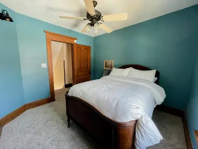a bedroom with a bed with a ceiling fan at 4BR-Beautiful Historic Home in Millersburg