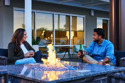 a group of people sitting around a table with a fire at Fairfield by Marriott Inn & Suites Cincinnati Oakley in Cincinnati