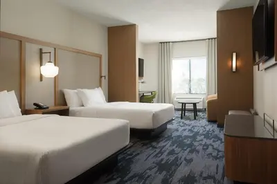 a hotel room with two beds and a desk at Fairfield by Marriott Inn & Suites Cincinnati Oakley in Cincinnati