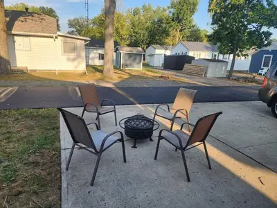 three chairs and a fire pit in a yard at A spacious getaway on Orchard Island in Russells Point