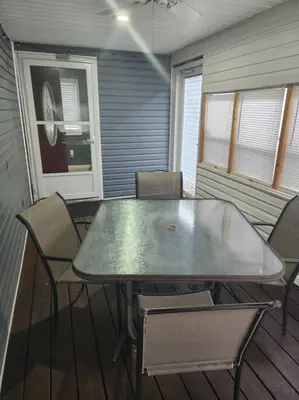 a table and chairs sitting on a porch with a table and chairs at A spacious getaway on Orchard Island in Russells Point