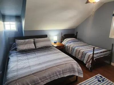 a bedroom with two beds and a table with a lamp at A spacious getaway on Orchard Island in Russells Point
