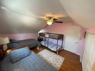 a room with two beds and a ceiling fan at A spacious getaway on Orchard Island in Russells Point