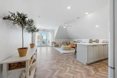 a kitchen and living room with white walls and wooden floors at The Washington Downtown Boutique Hotel in Sandusky
