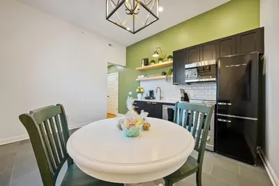 a kitchen with a white table and chairs and a black refrigerator at The Washington Downtown Boutique Hotel in Sandusky