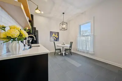 a kitchen with a table and a vase of yellow flowers at The Washington Downtown Boutique Hotel in Sandusky