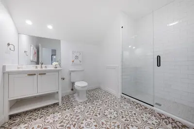 a white bathroom with a toilet and a shower at The Washington Downtown Boutique Hotel in Sandusky