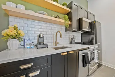 a kitchen with gray cabinets and a sink at The Washington Downtown Boutique Hotel in Sandusky