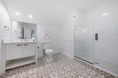 a white bathroom with a toilet and a shower at The Washington Downtown Boutique Hotel in Sandusky
