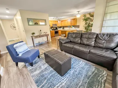 a living room with a leather couch and a blue chair at On Island Time at Kelleys Island Condo! in Kelleys Island