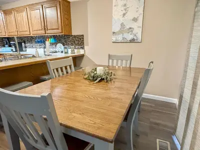 a dining room with a wooden table and chairs at On Island Time at Kelleys Island Condo! in Kelleys Island