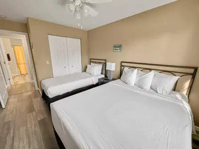 a bedroom with two beds with white sheets at On Island Time at Kelleys Island Condo! in Kelleys Island