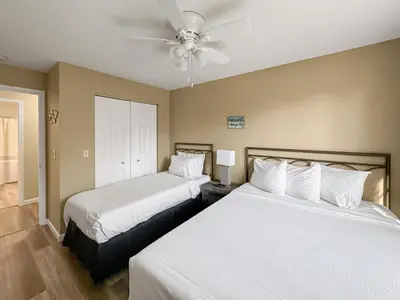 a bedroom with two beds and a ceiling fan at On Island Time at Kelleys Island Condo! in Kelleys Island