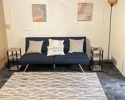 a blue couch sitting in a room with two tables at The Cozy Corner in Toledo