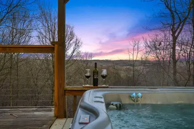 a hot tub with wine glasses and wine bottles at Hot tub, fireplace, fire pit, pool table, grill, EV, pets, HOA lake in Amanda
