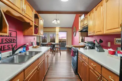 a kitchen with wooden cabinets and a sink at Hot tub, fireplace, fire pit, pool table, grill, EV, pets, HOA lake in Amanda