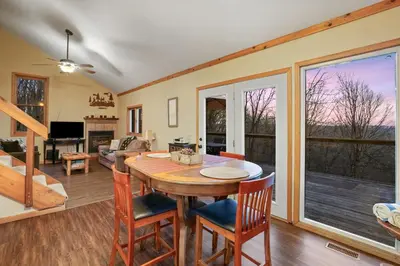 a dining room and living room with a table and chairs at Hot tub, fireplace, fire pit, pool table, grill, EV, pets, HOA lake in Amanda